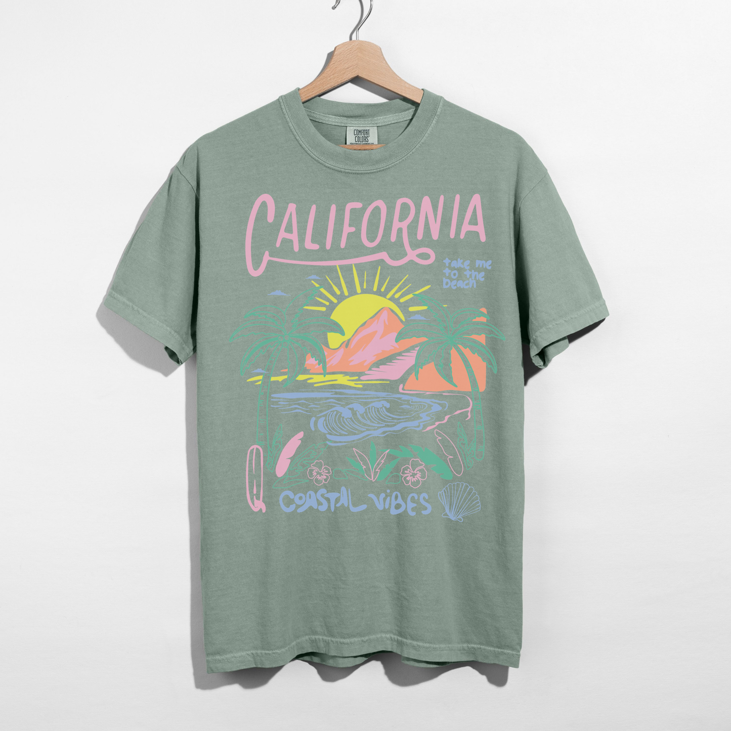 Bay green California Coastal Vibes graphic tee with pastel sunset and ocean design