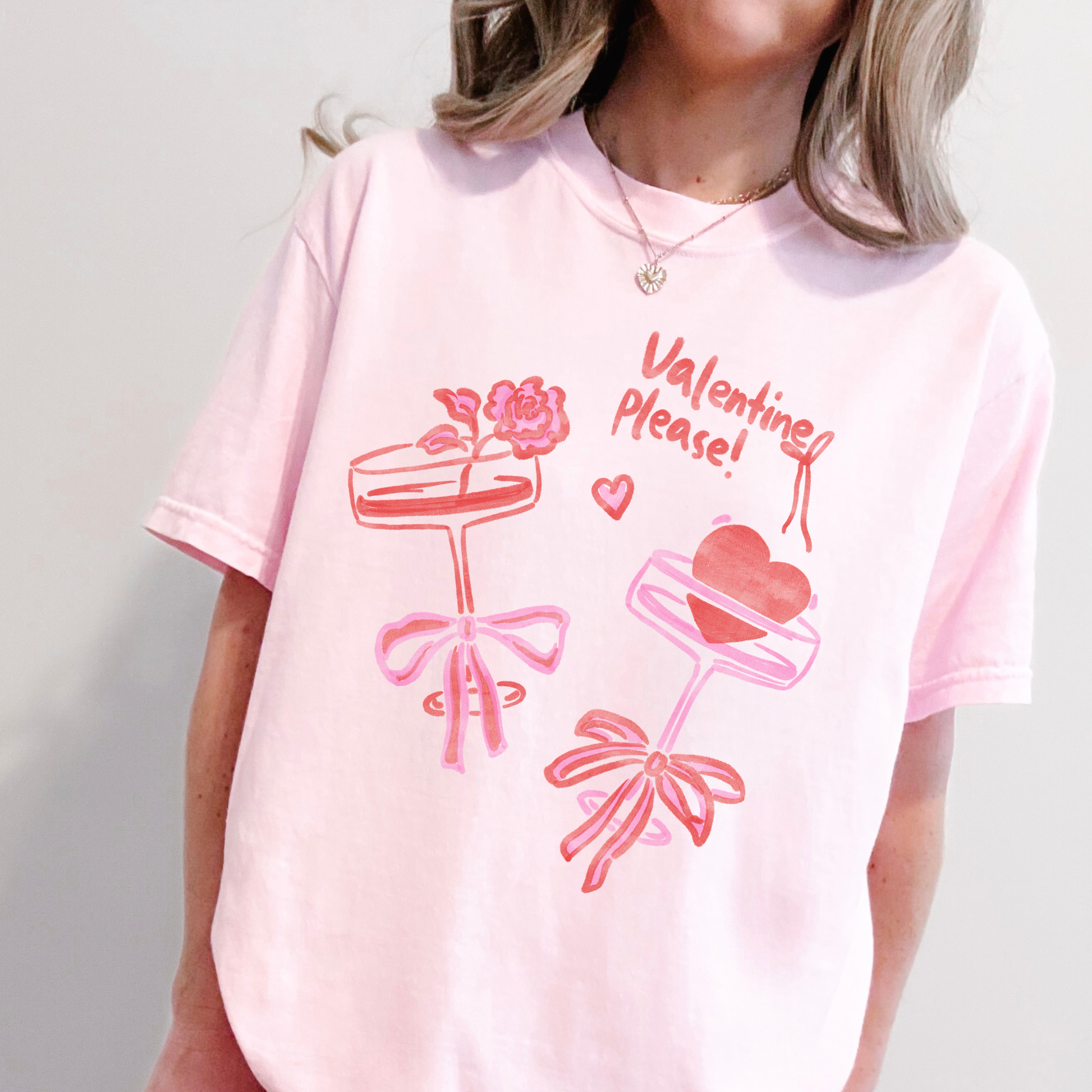 Woman wearing pink Valentine Please t-shirt with heart and floral cocktail glass design.