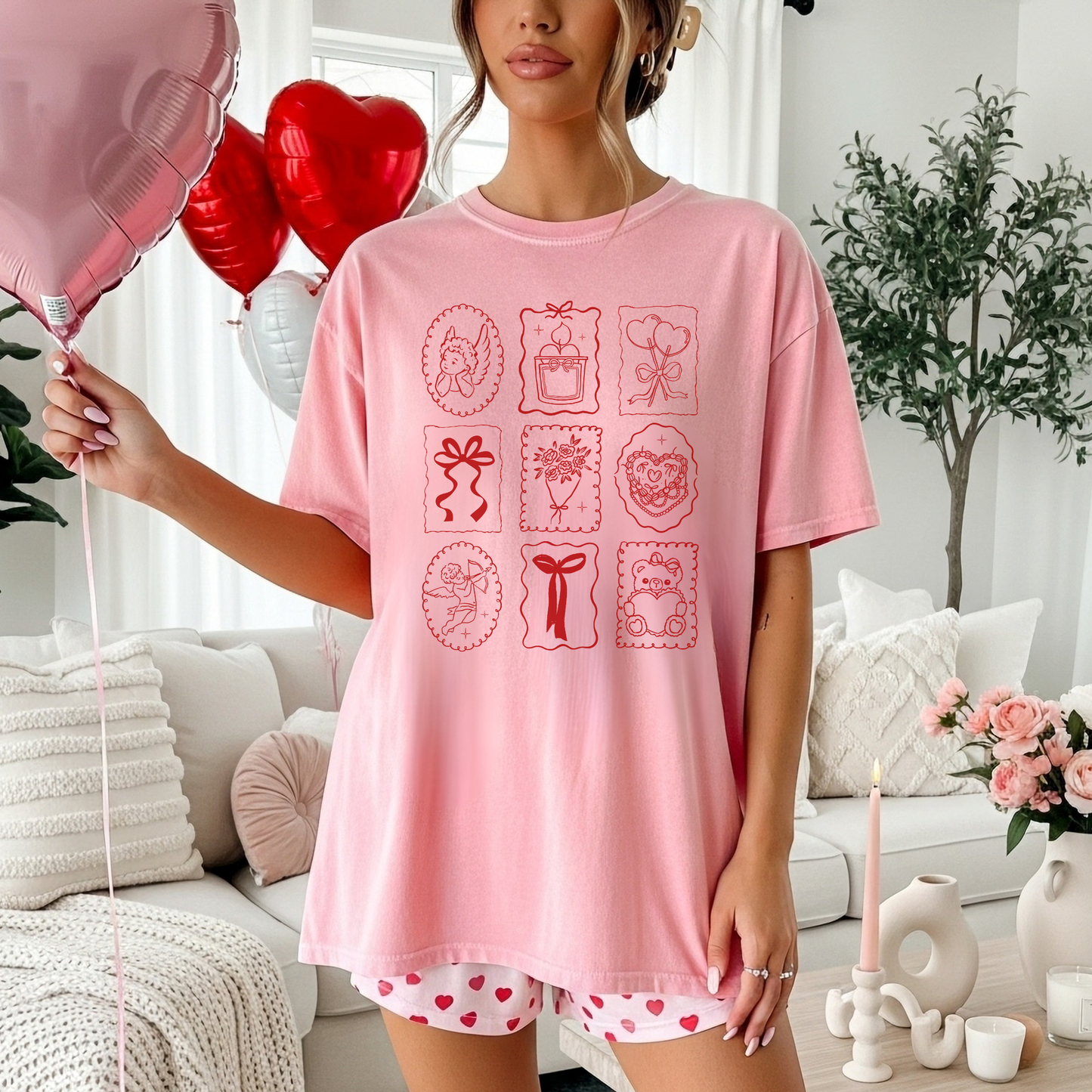 Woman wearing blossom Valentine stamp icons tee holding a balloon in a cozy living room.