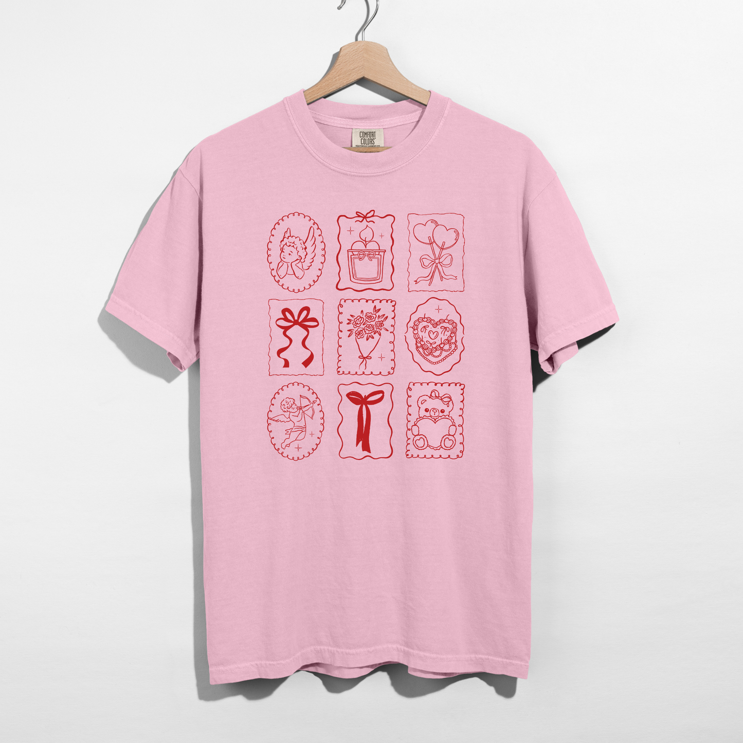 Blossom Comfort Colors tee with red Valentine stamp icons graphic on hanger.