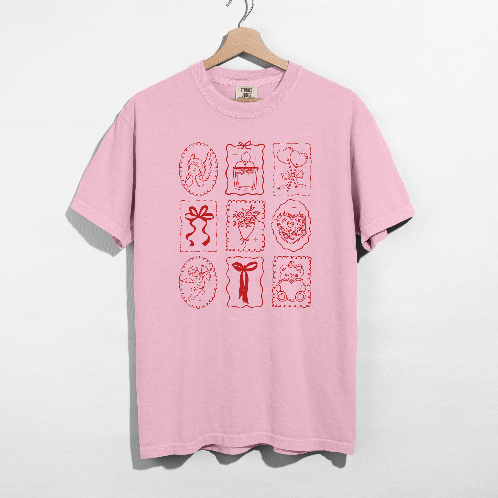 Blossom Comfort Colors tee with red Valentine stamp icons graphic on hanger.
