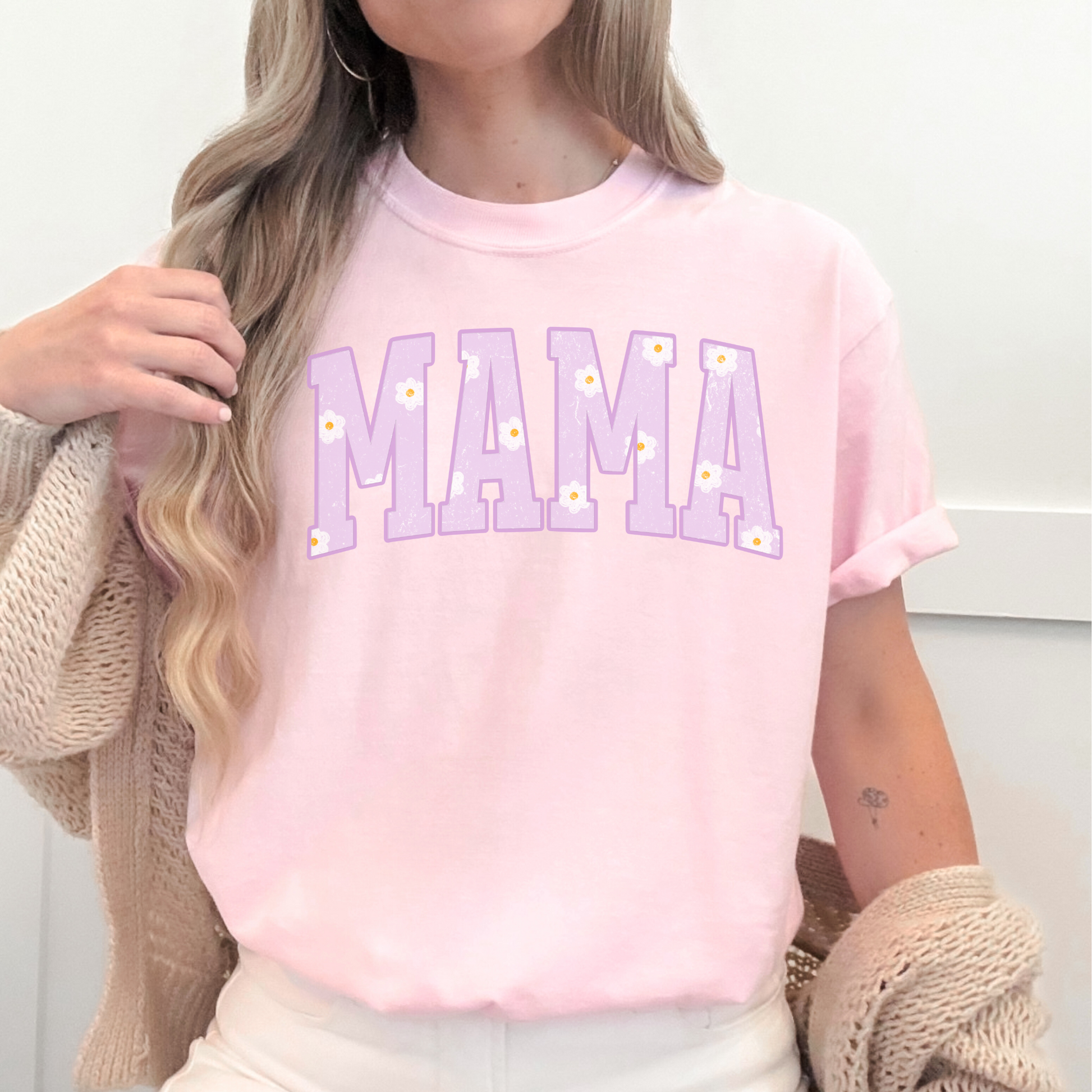 Woman wearing a light pink Comfort Colors mama graphic t-shirt with soft purple floral mama design, cozy boutique style