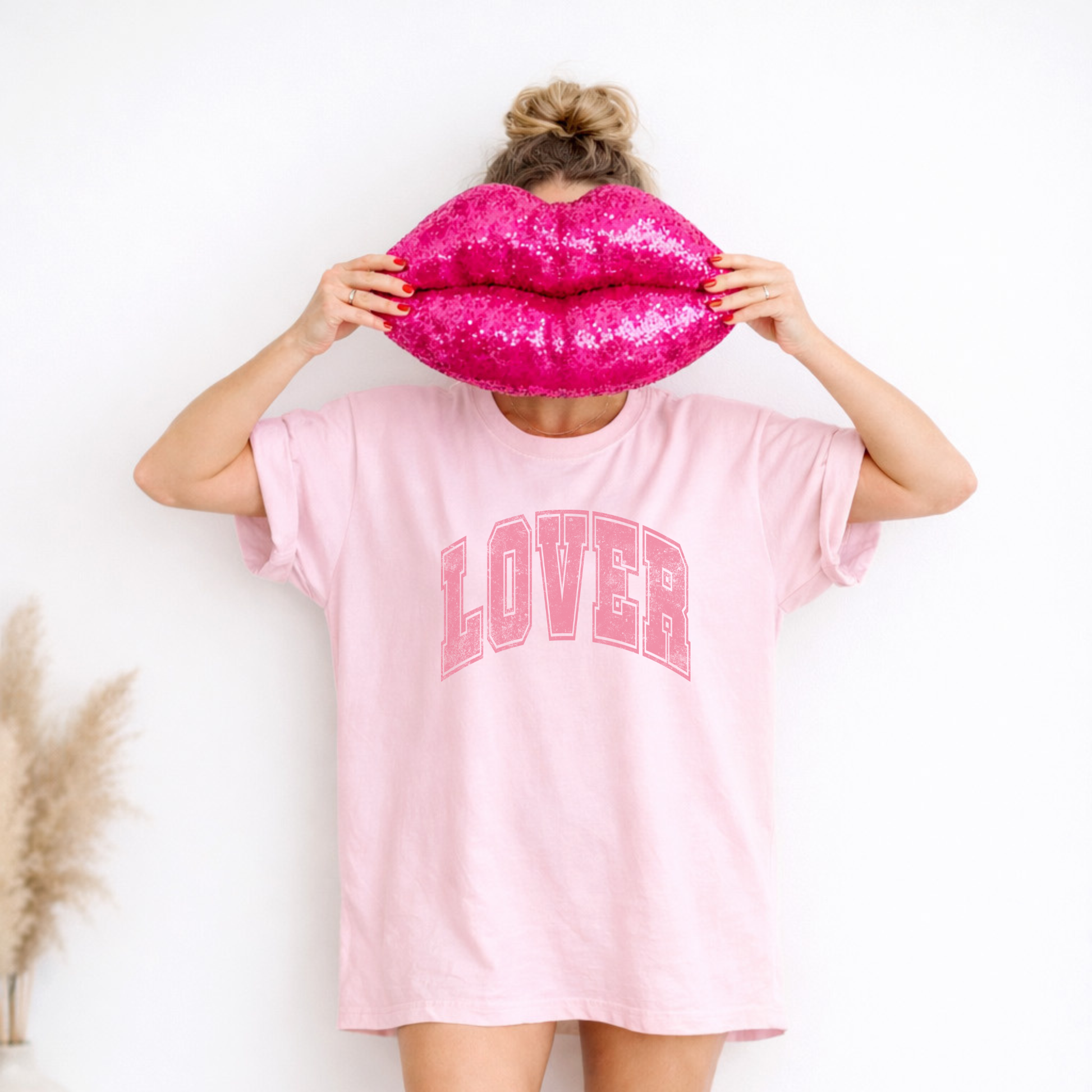 Model wearing pink Lover graphic tee with oversized fit and rolled sleeves