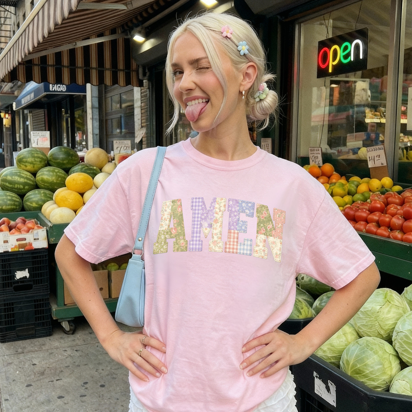 Woman wearing pink AMEN faux patchwork graphic t-shirt styled casually outdoors