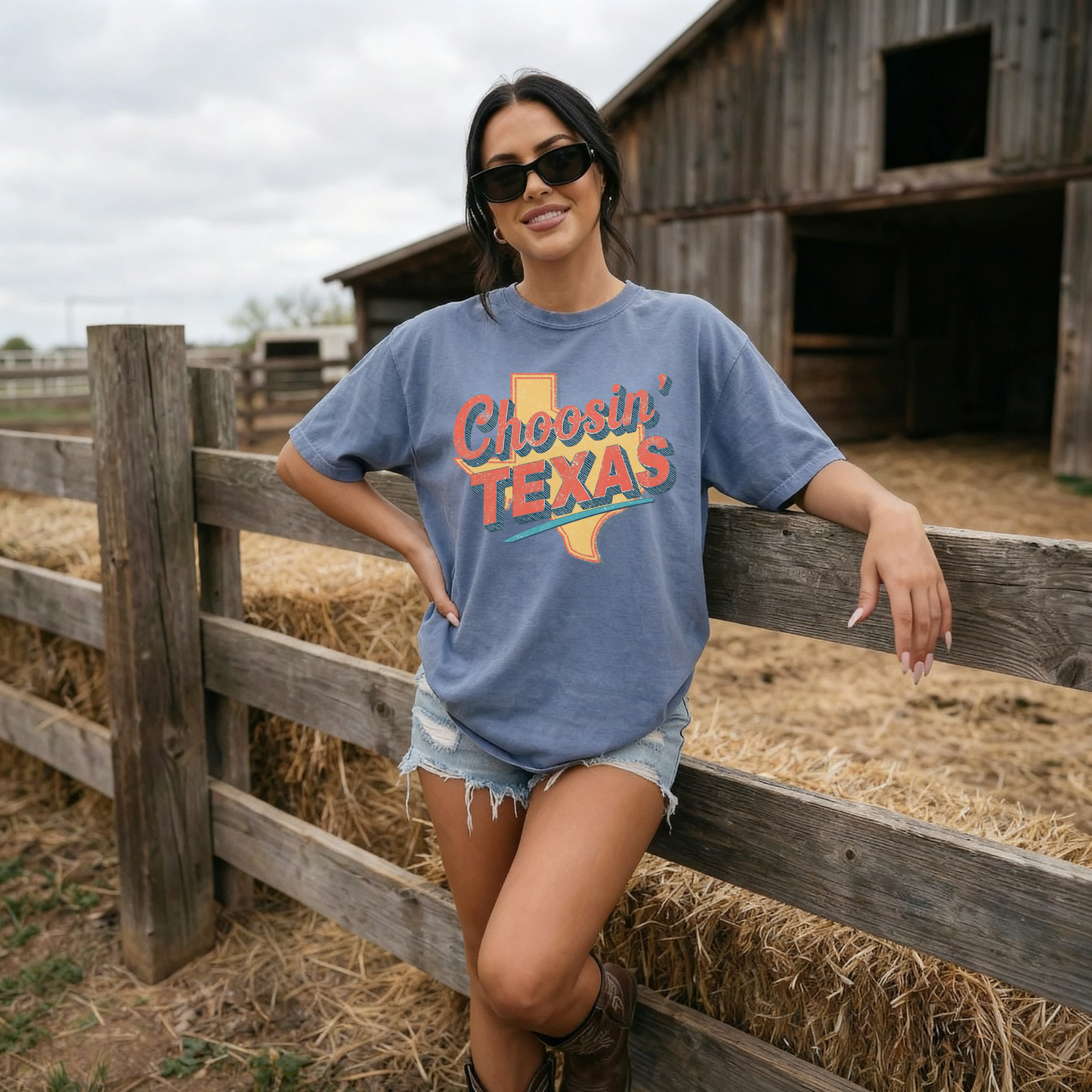 Woman wearing blue Choosin Texas vintage state pride t-shirt leaning on wooden fence