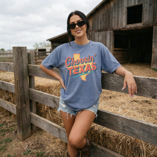 Woman wearing blue Choosin Texas vintage state pride t-shirt leaning on wooden fence