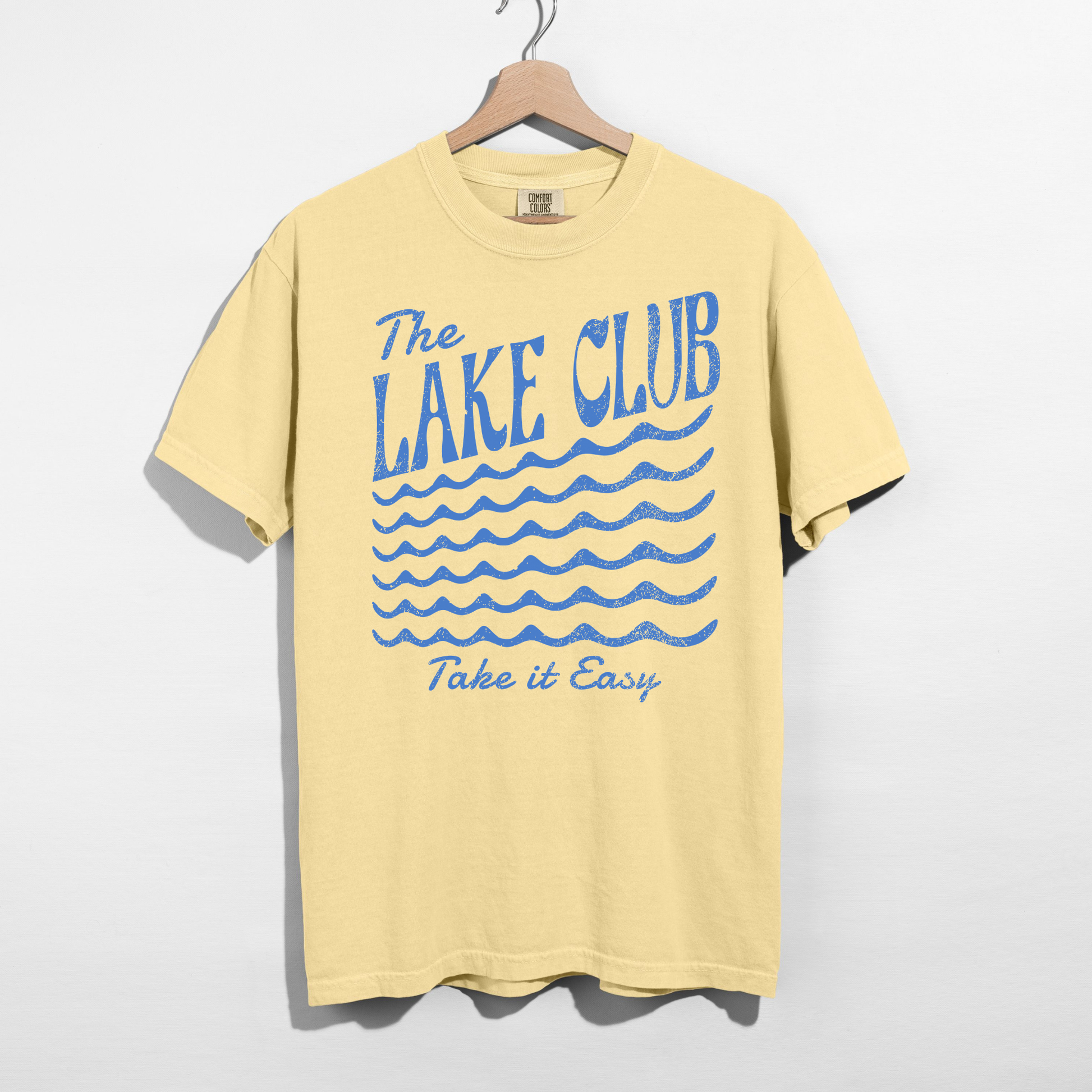 Butter yellow Comfort Colors t-shirt featuring The Lake Club Take It Easy distressed blue lake graphic and wave design