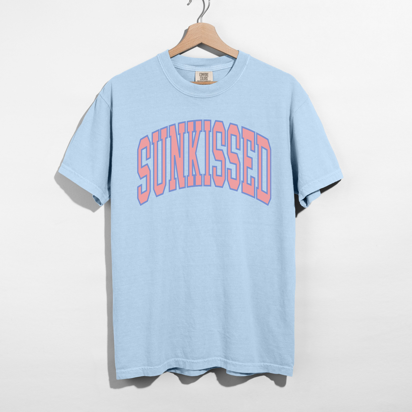Light blue SUNKISSED graphic tee featuring retro collegiate lettering, casual summer t-shirt