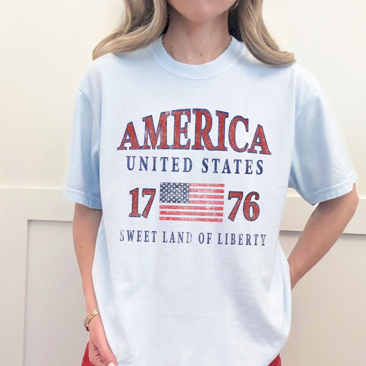 Model wearing America 1776 patriotic USA graphic tee styled casually