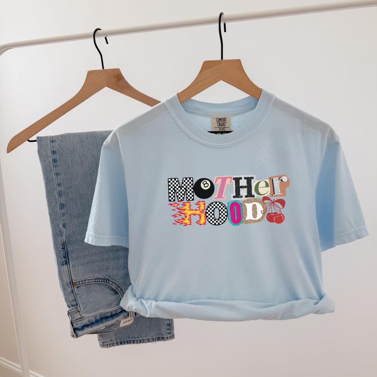 Light blue Mother Hood graphic tee flat lay with denim shorts