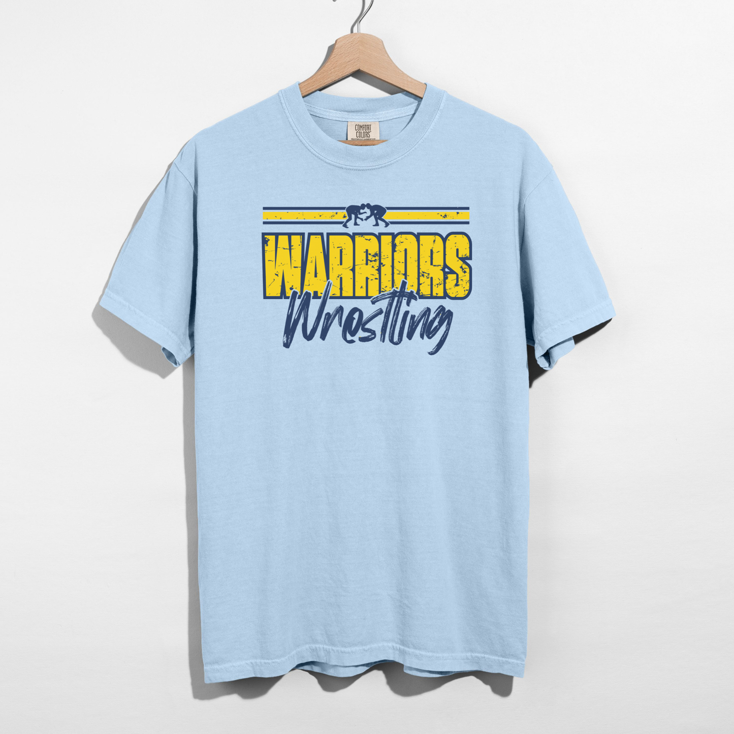 Light blue t-shirt with 'Warriors Wrestling' text on a hanger against a white background