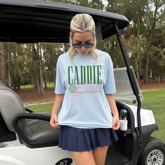 Caddie Baddie graphic tee styled with tennis skirt at golf course cute women’s golf outfit