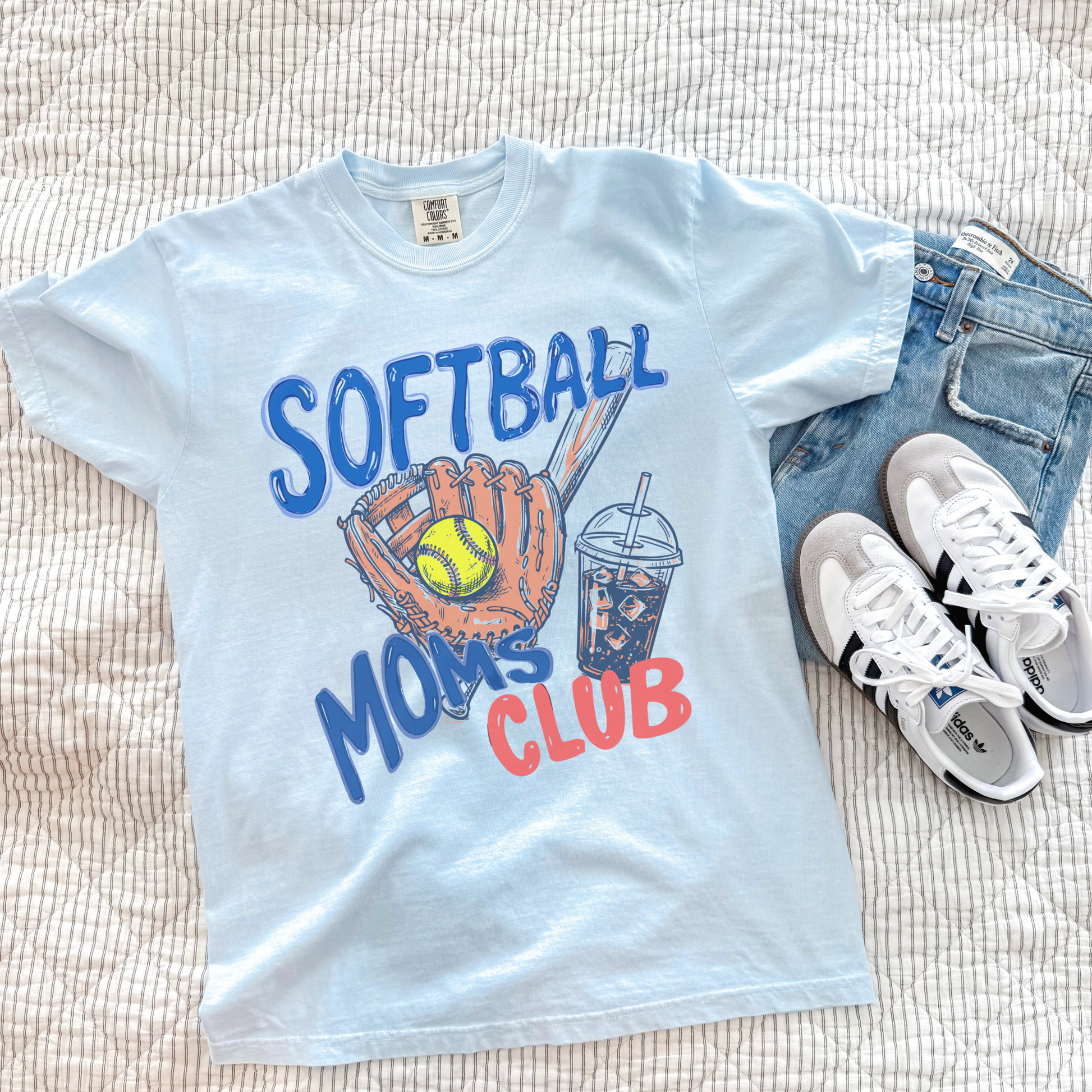 Light blue Softball Moms Club graphic tee styled with denim shorts and sneakers