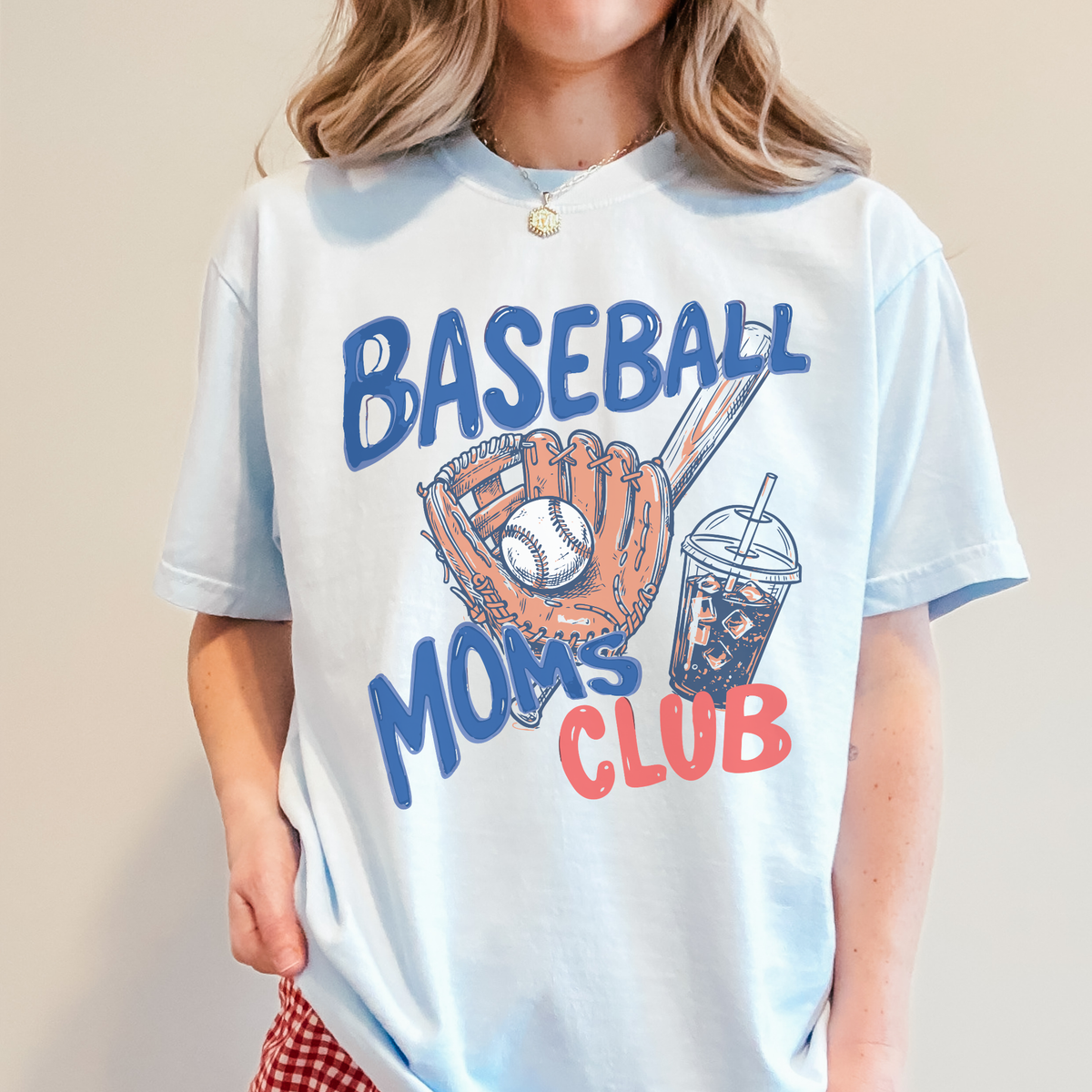 Woman wearing light blue Baseball Moms Club graphic tee with glove and iced coffee design