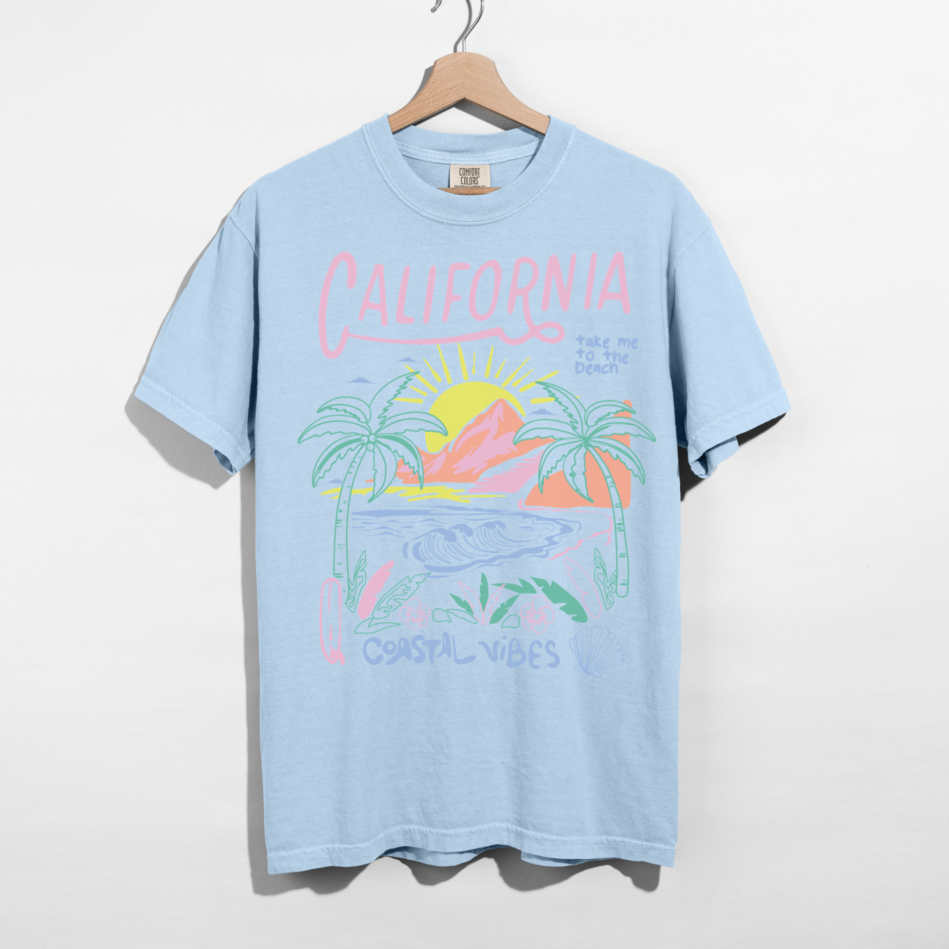 Chambray Comfort Colors California Coastal Vibes shirt hanging with pastel beach graphic