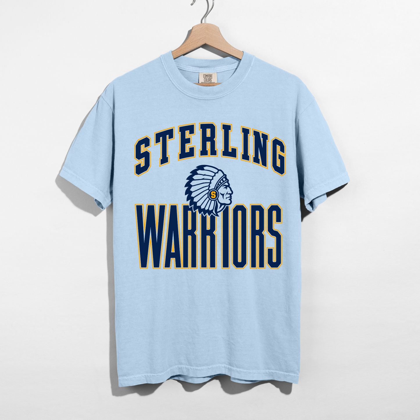 Chambray blue Sterling Warriors mascot graphic t-shirt with navy and gold collegiate lettering displayed on a hanger.