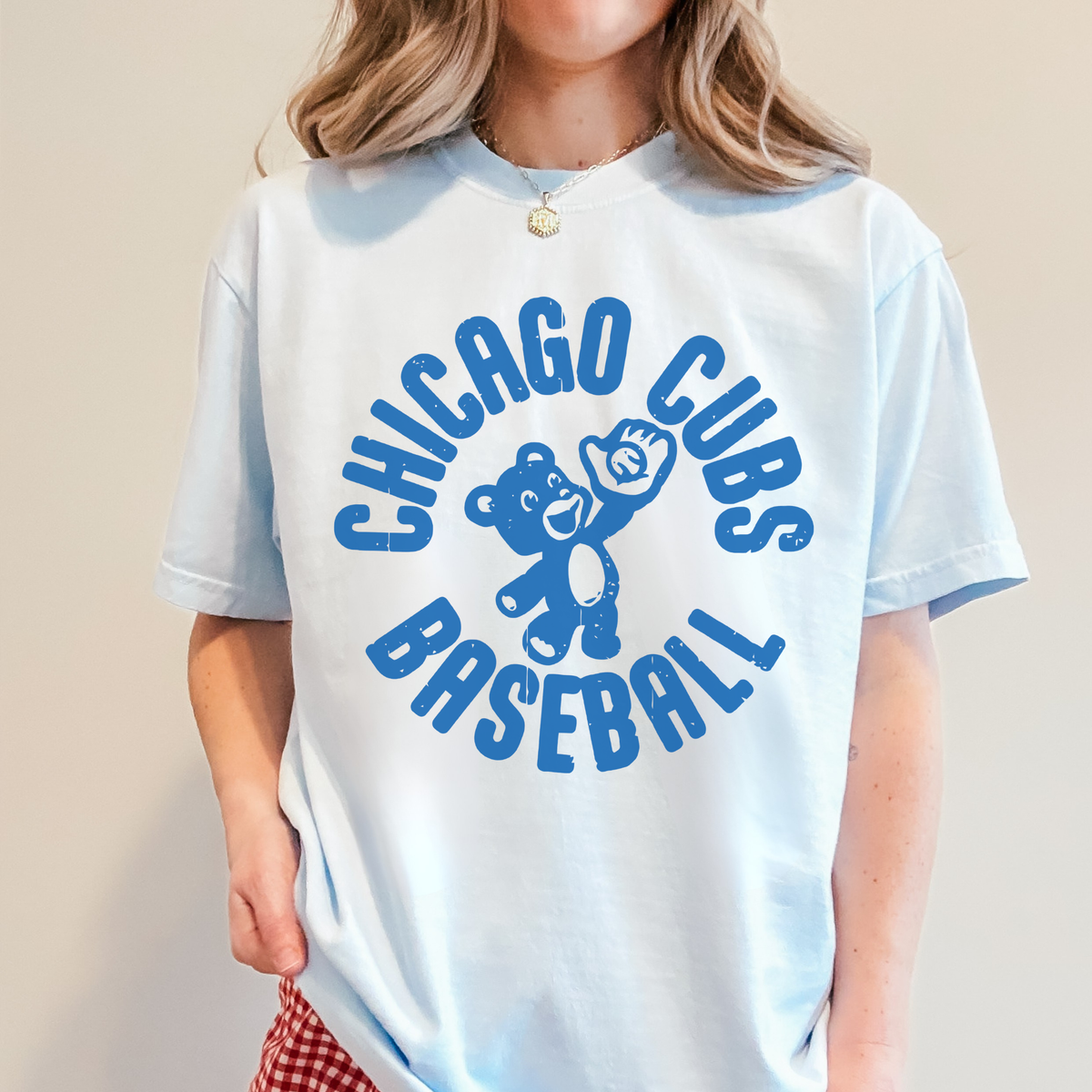 Woman wearing chambray blue Chicago Cubs Baseball vintage graphic t-shirt with bold collegiate arc lettering.