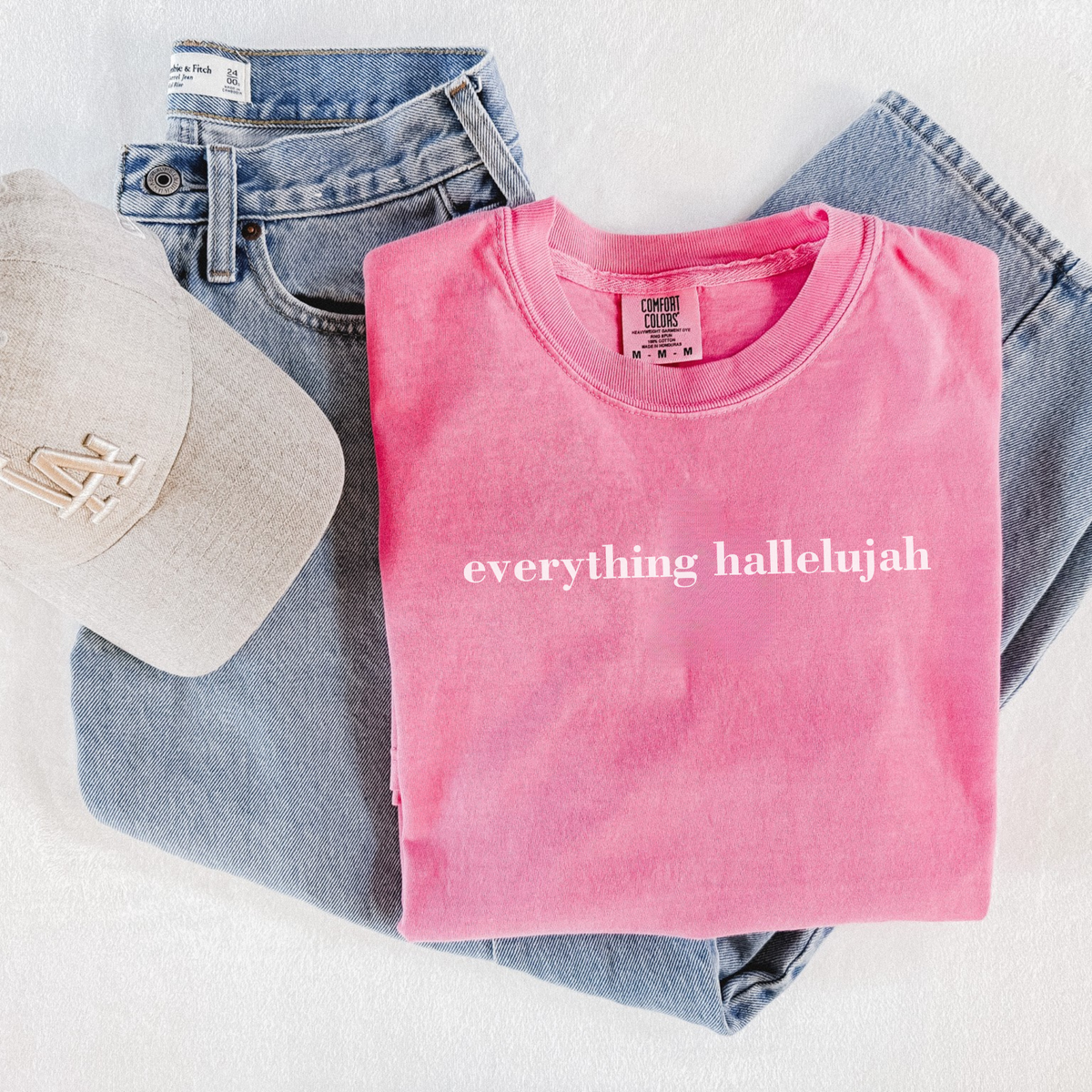 Pink Everything Hallelujah faith graphic t-shirt styled with denim jeans and neutral baseball cap