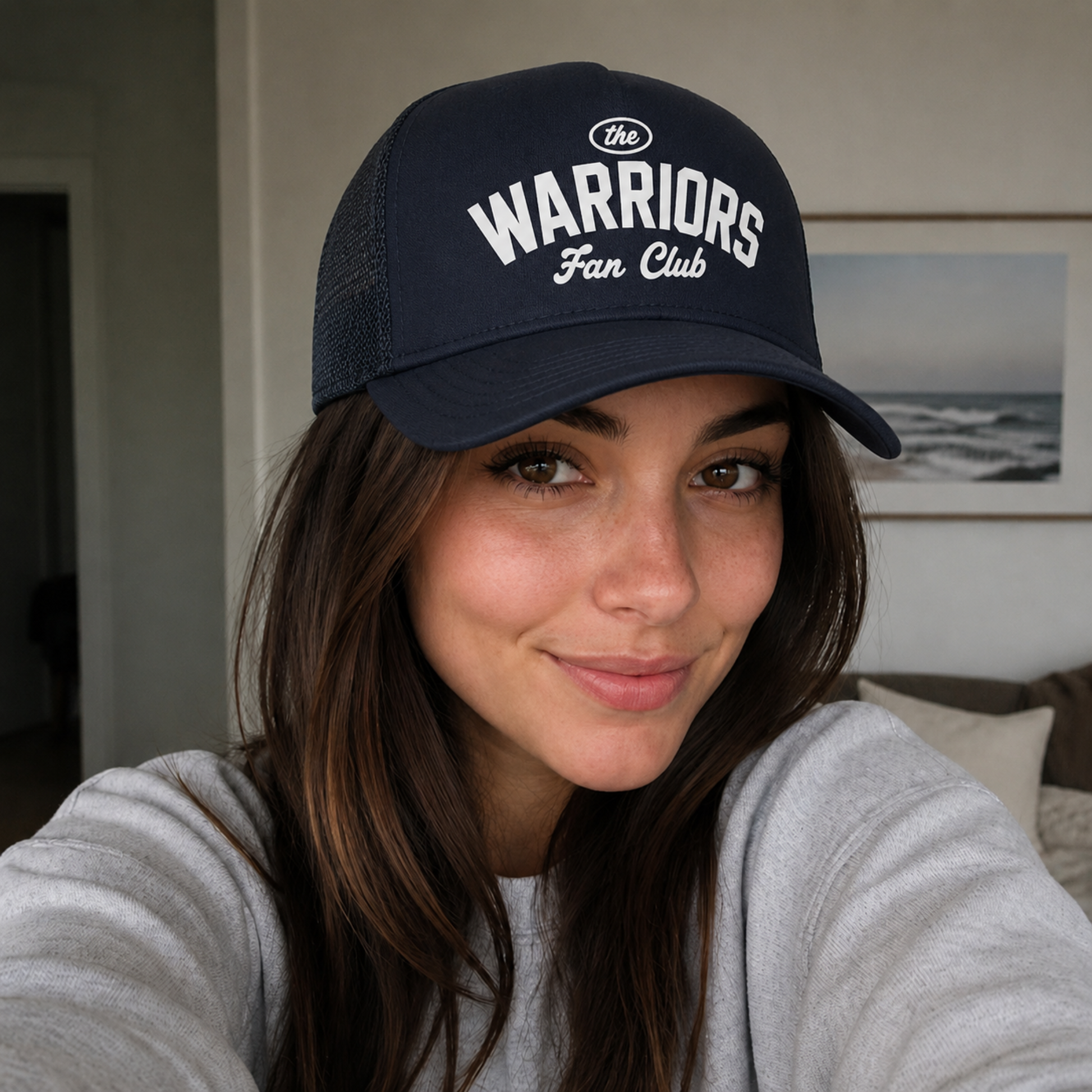 Woman wearing a navy Warriors Fan Club trucker hat featuring a vintage athletic design and breathable mesh back.
