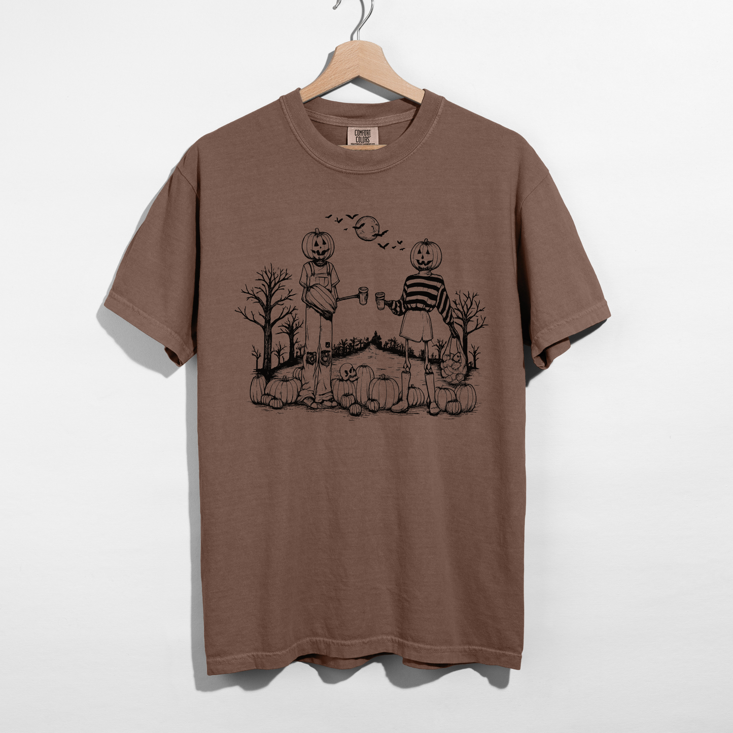 Espresso brown Halloween graphic t-shirt featuring two pumpkin-headed best friends, pumpkins, bats, trees, and a spooky moon.