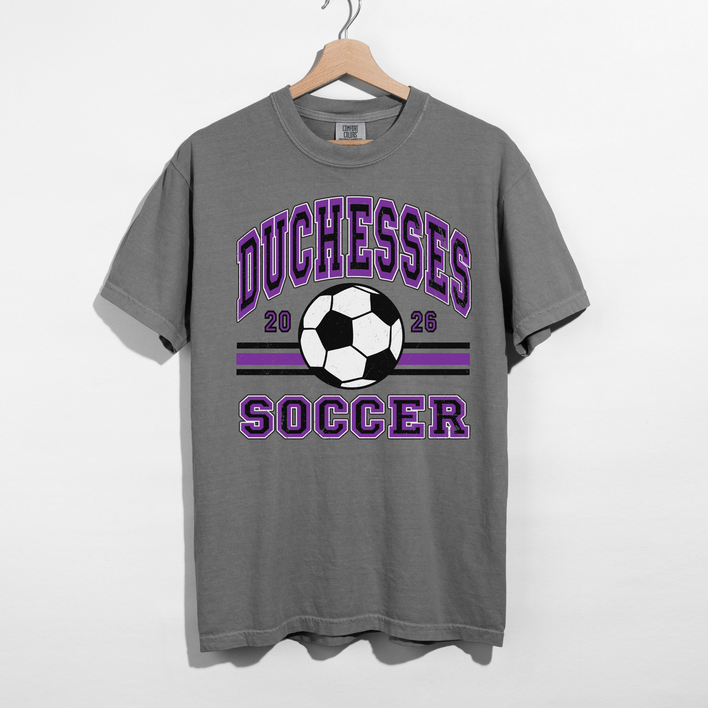 Duchesses Soccer 2026 graphic on grey Comfort Colors t-shirt hanging on hanger