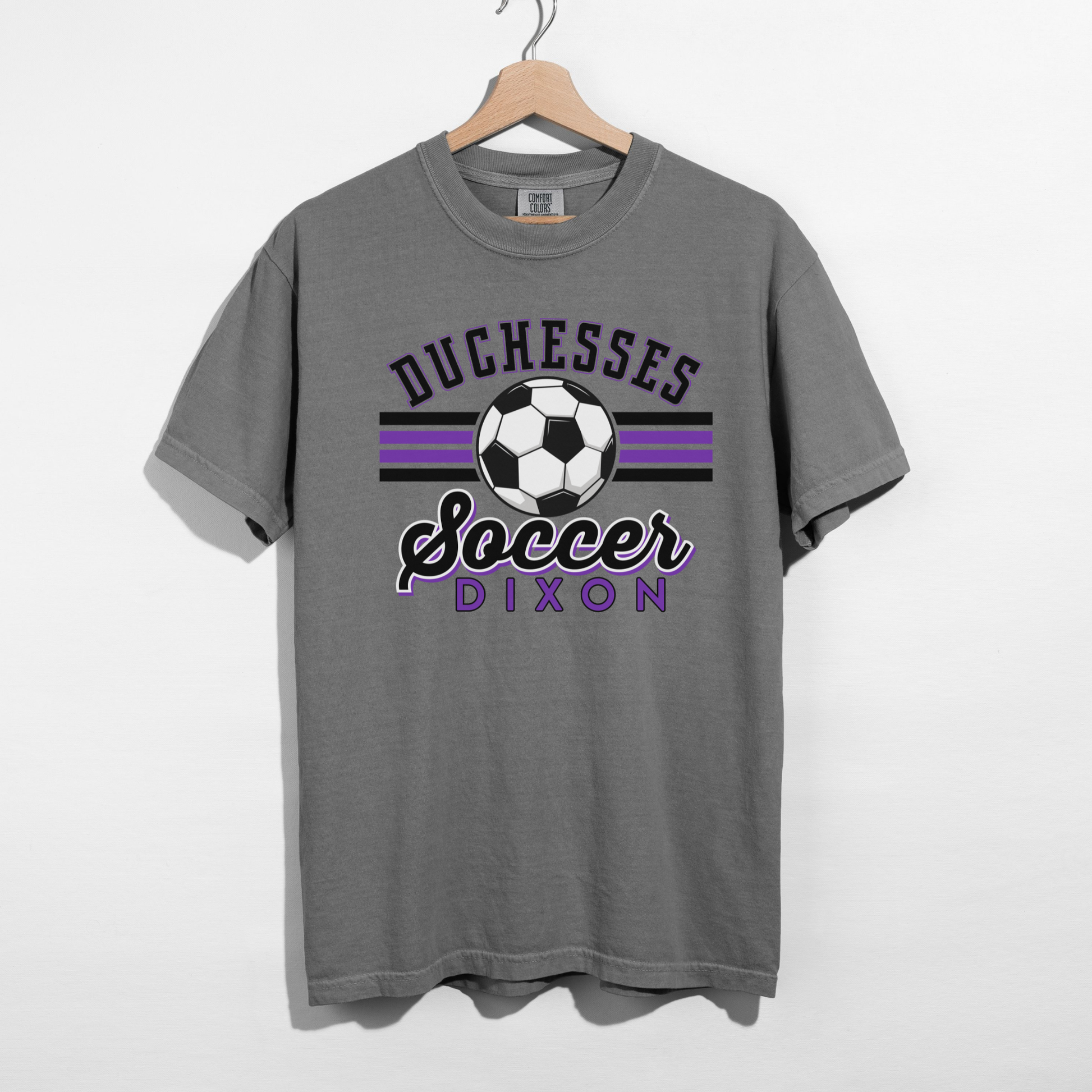 Duchesses Soccer Dixon graphic tee displayed on dark grey shirt flat lay
