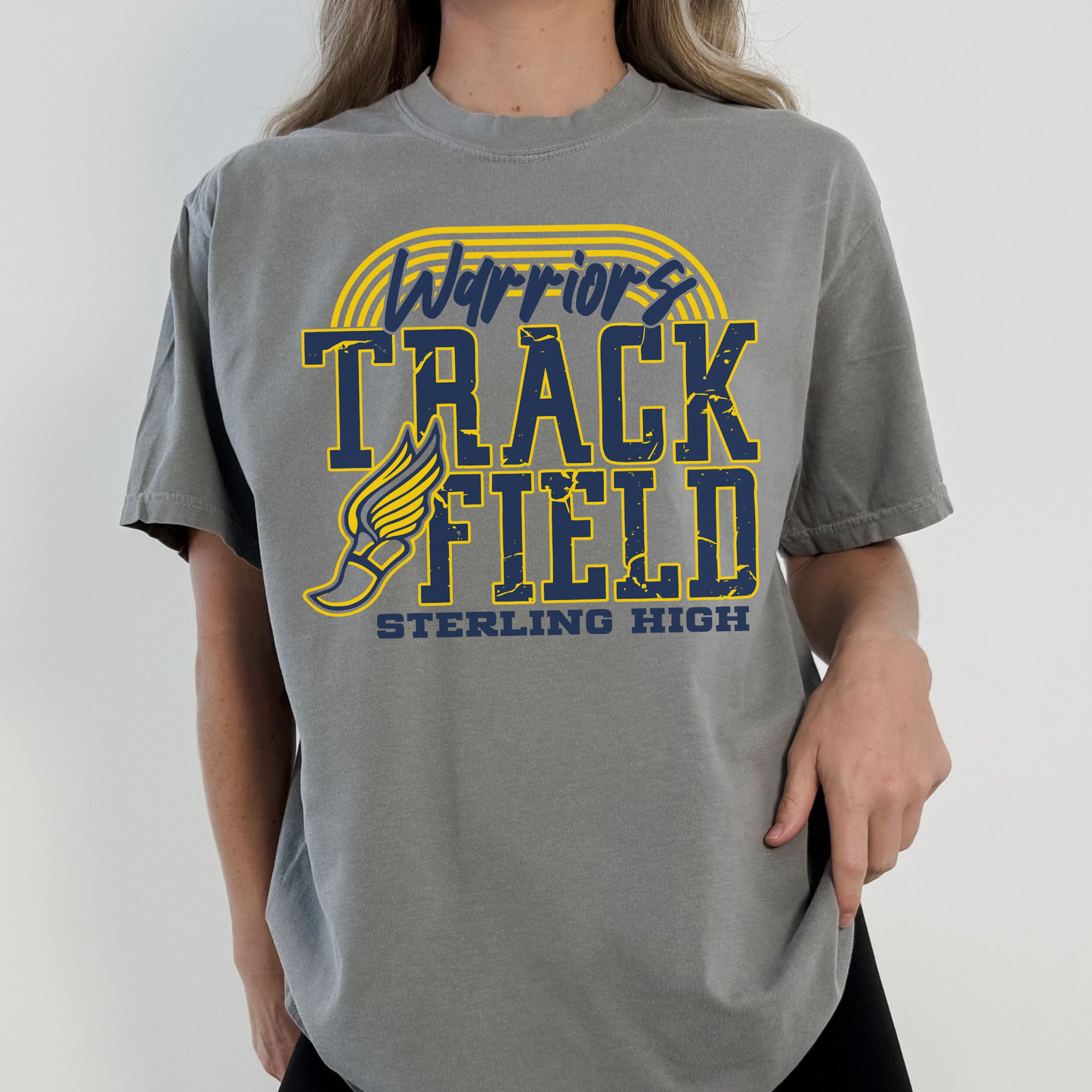 Person wearing a gray t-shirt with 'Warriors Track Field Sterling High' design.