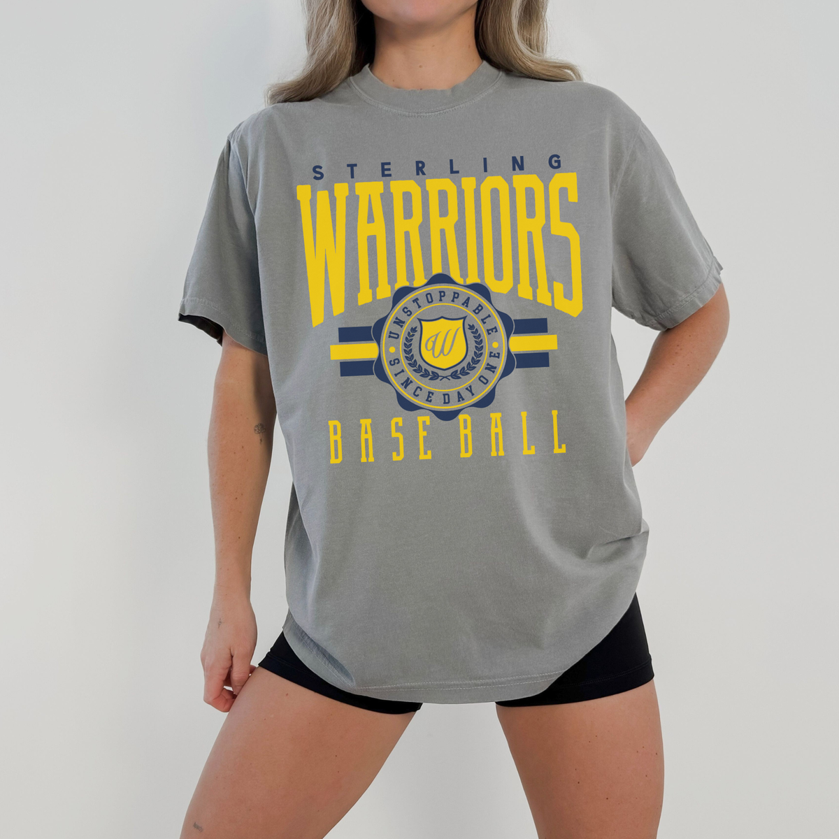 Person wearing a gray t-shirt with 'Sterling Warriors Baseball' text and design.