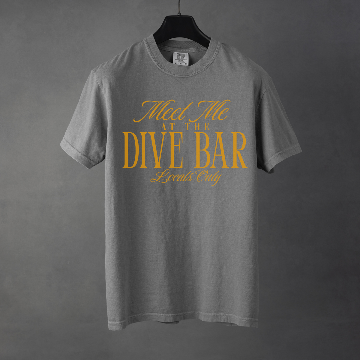Gray t-shirt with yellow text 'Meet Me at the Dive Bar Locals Only' on a gray background