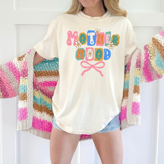 “Ivory Motherhood graphic tee with retro floral letters and pink bow.”