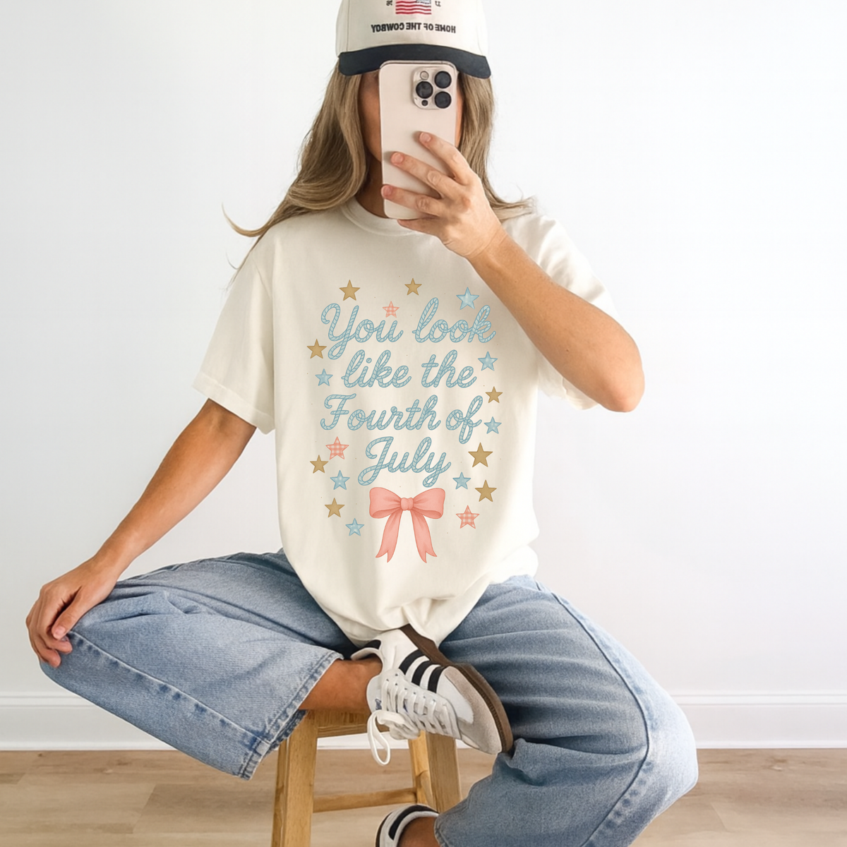 Lifestyle photo of patriotic graphic tee featuring stars and bow detail for Fourth of July outfit