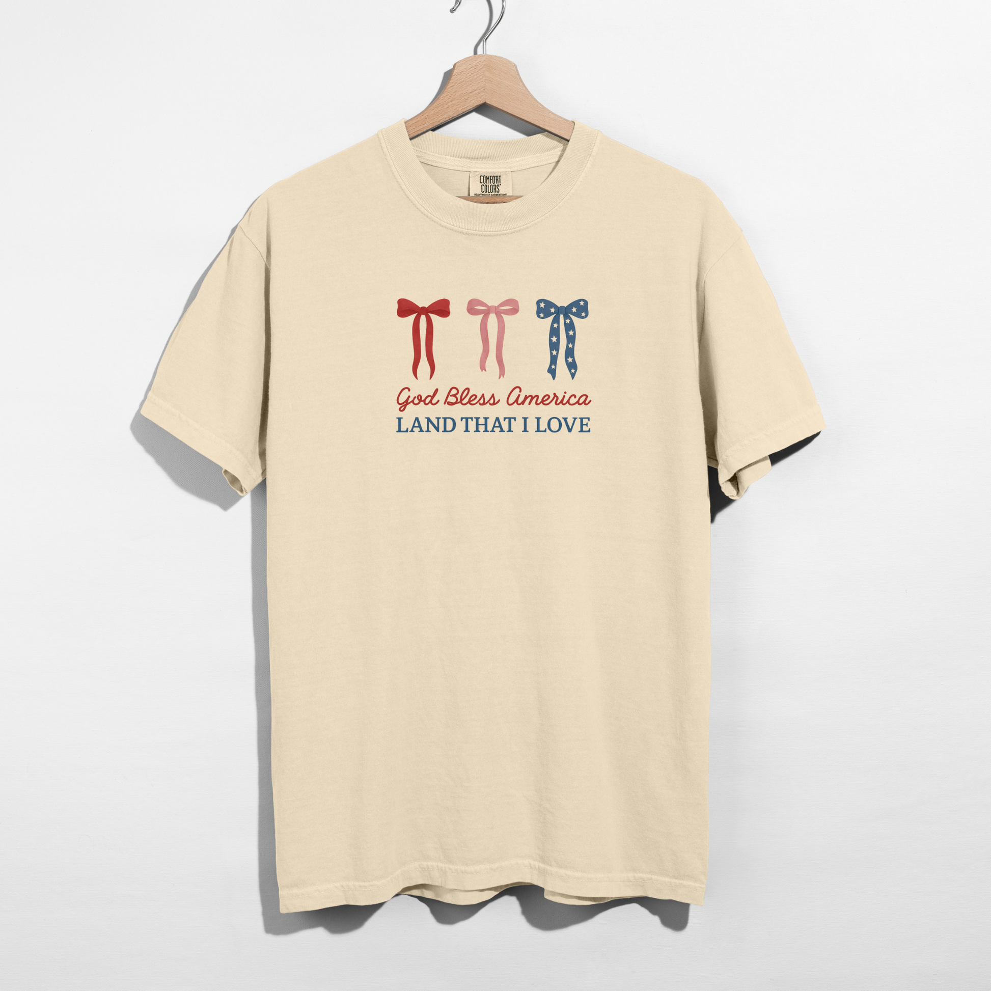 Patriotic bow graphic t-shirt hanging on hanger neutral background