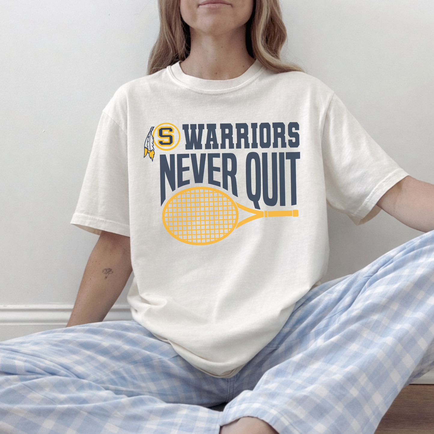Woman wearing an ivory Warriors Never Quit Sterling Warriors tennis t-shirt styled casually