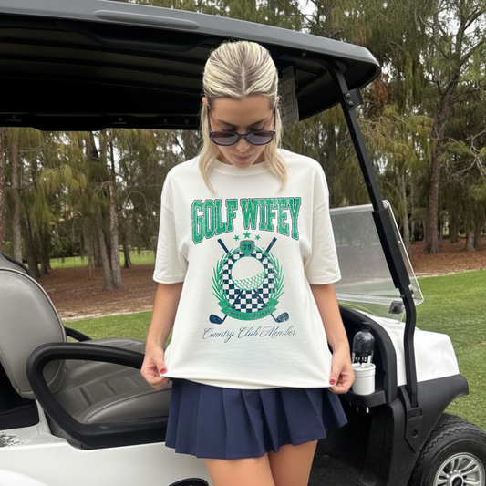 woman wearing golf wifey graphic tee country club outfit with tennis skirt golf course outfit women