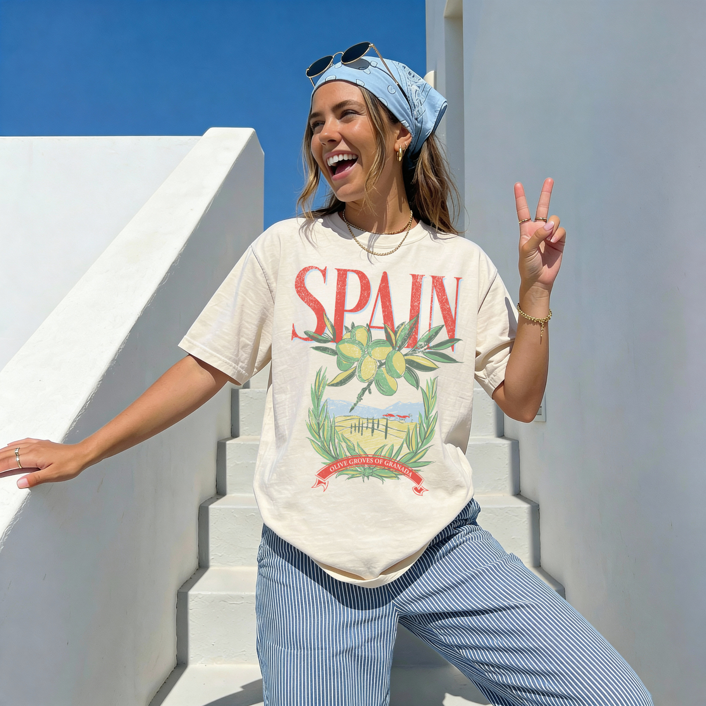 Woman wearing ivory Spain olive grove graphic tee with red lettering and vintage travel design outdoors