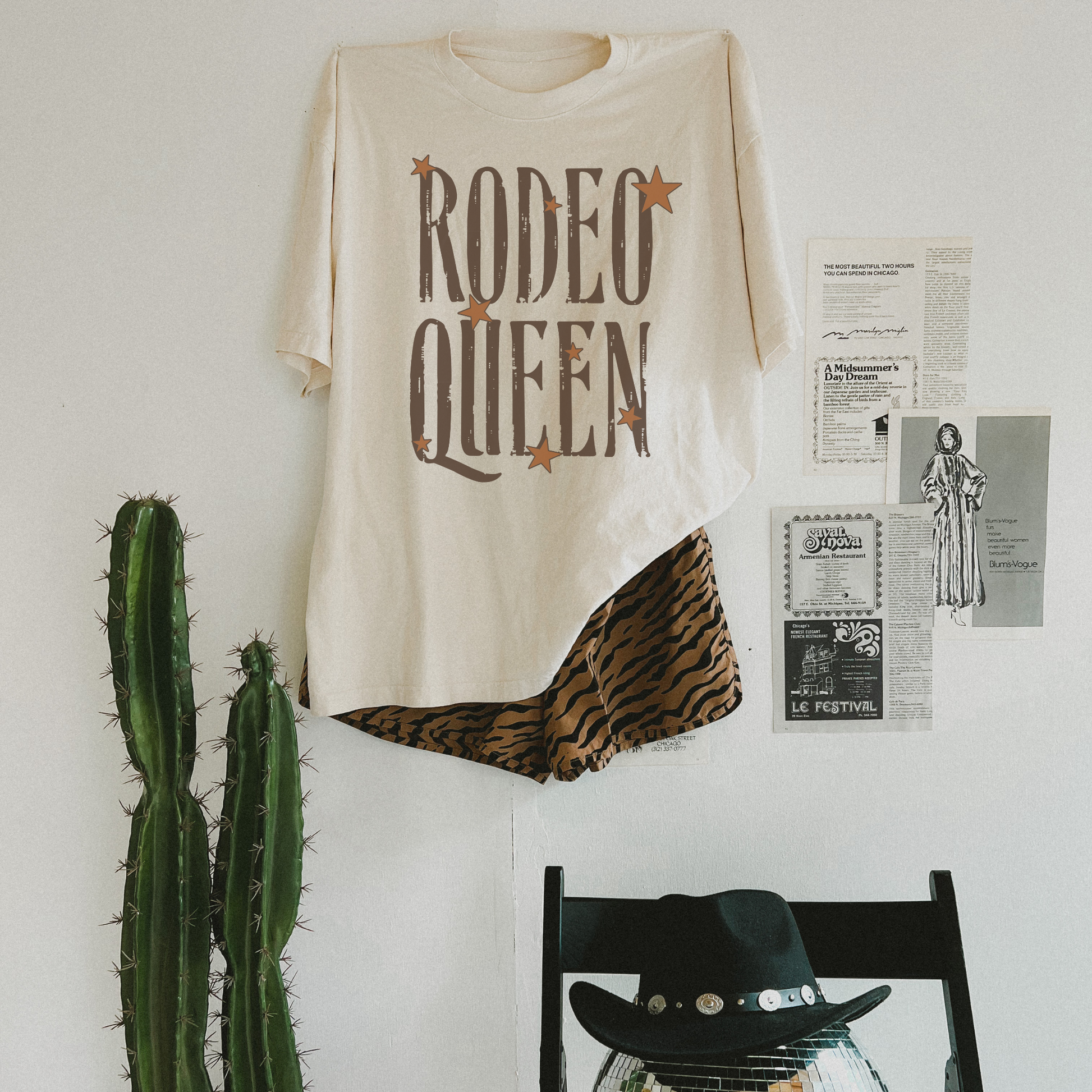 Rodeo Queen graphic tee flat lay styled with western decor and patterned shorts