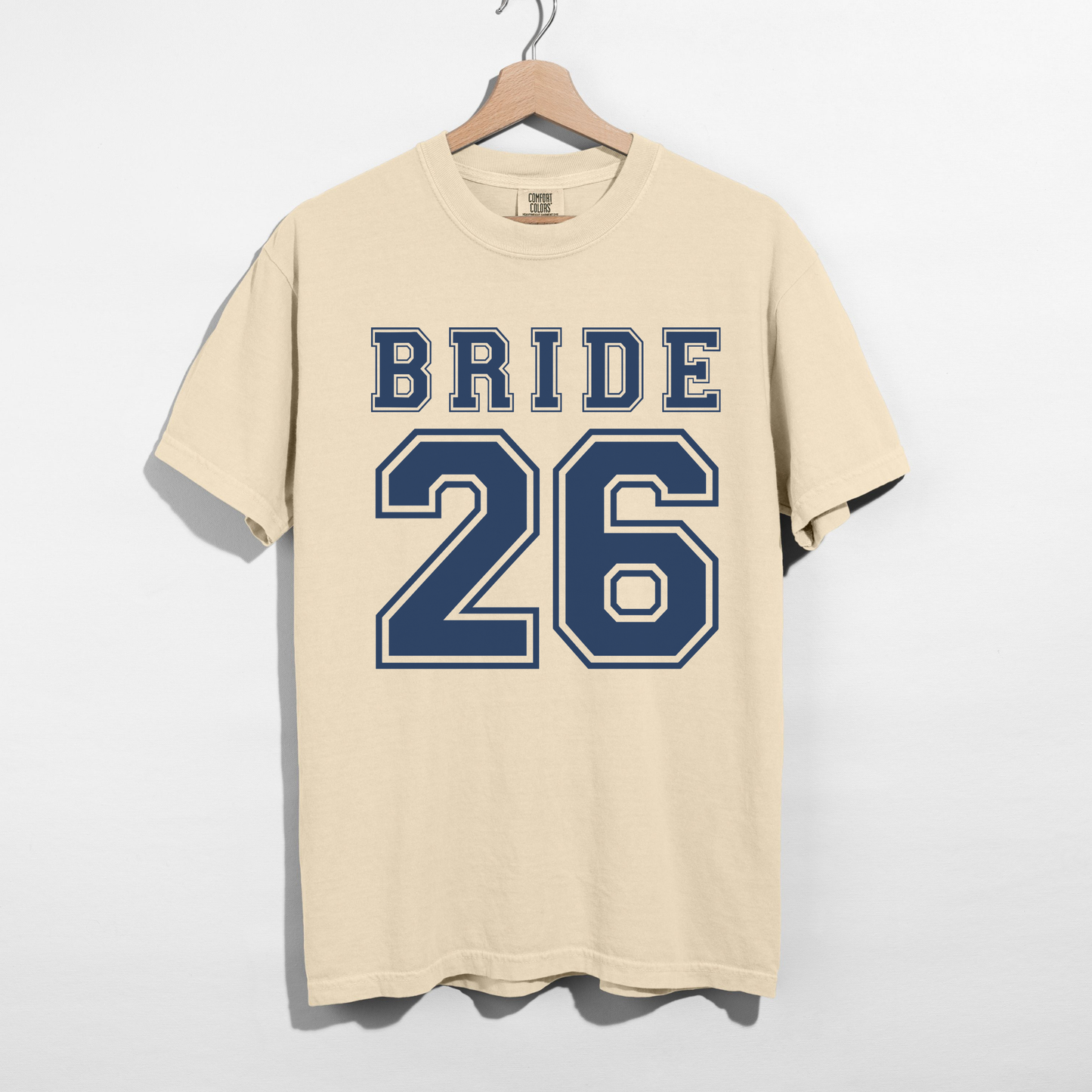 Ivory Comfort Colors Bride 26 varsity bridal graphic t-shirt flat lay mockup