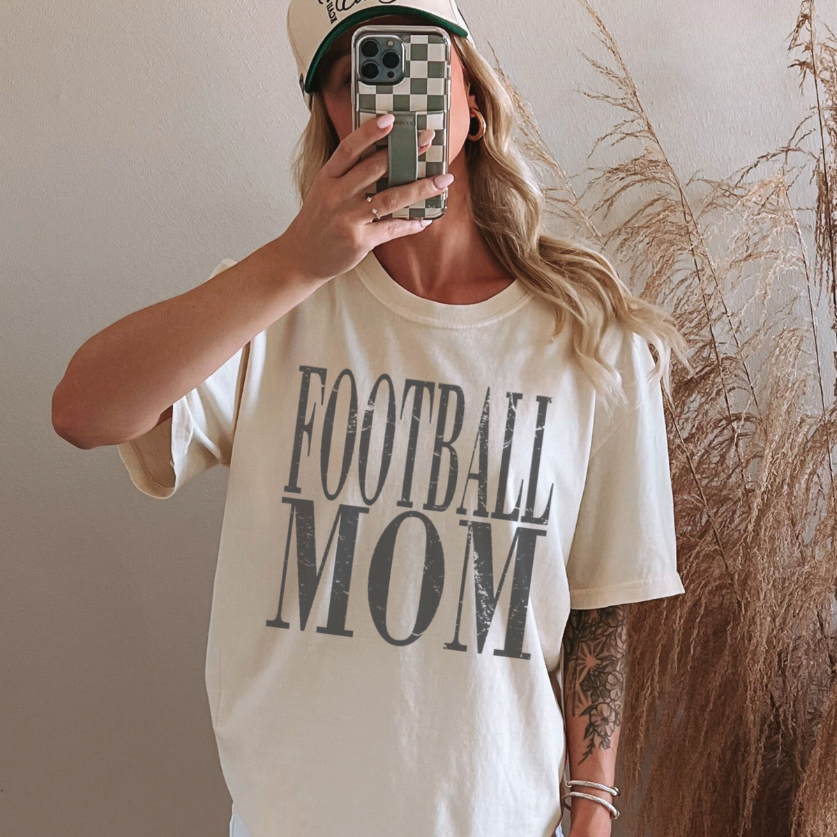 Person wearing a 'FOOTBALL MOM' t-shirt taking a mirror selfie.