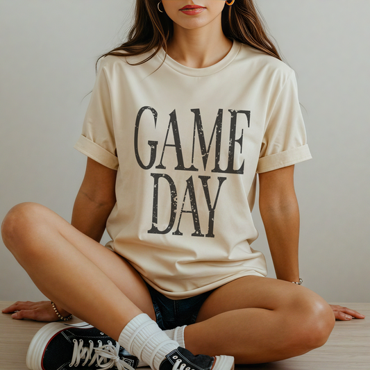 Person wearing a 'GAME DAY' t-shirt sitting on the floor.