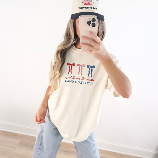 Woman wearing God Bless America bow graphic tee with red white and blue bows