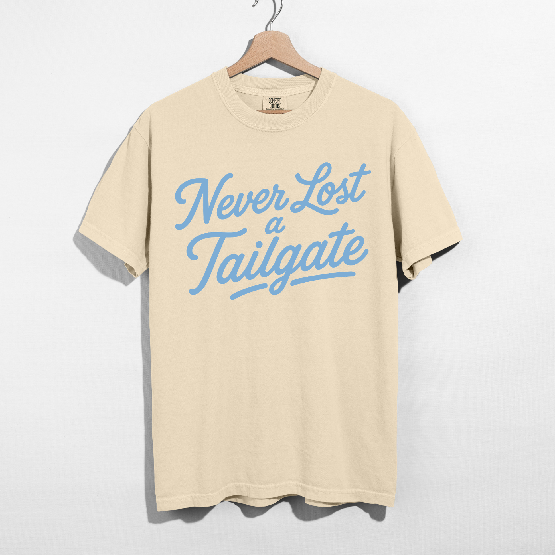 Never Lost a Tailgate ivory graphic tee with Carolina blue lettering for football tailgates