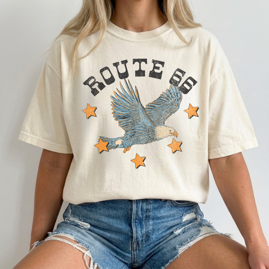 Closeup ivory Comfort Colors Route 66 eagle graphic t-shirt paired with distressed denim shorts