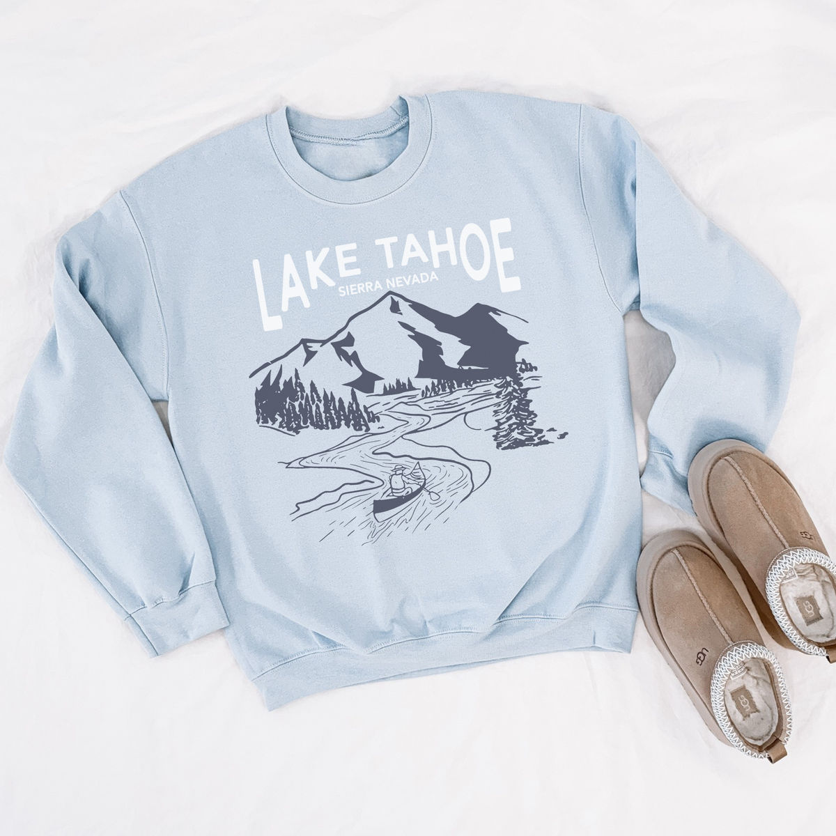 Light blue Lake Tahoe mountain graphic sweatshirt styled flat with cozy slippers