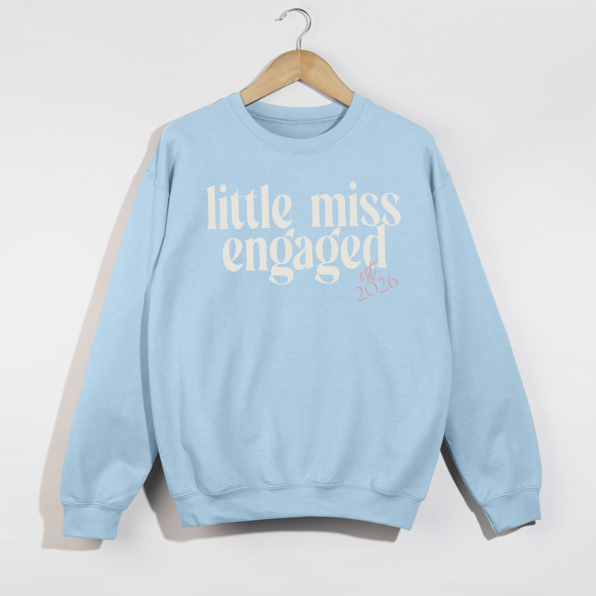 Light blue Little Miss Engaged Est. 2026 bridal crewneck sweatshirt on hanger