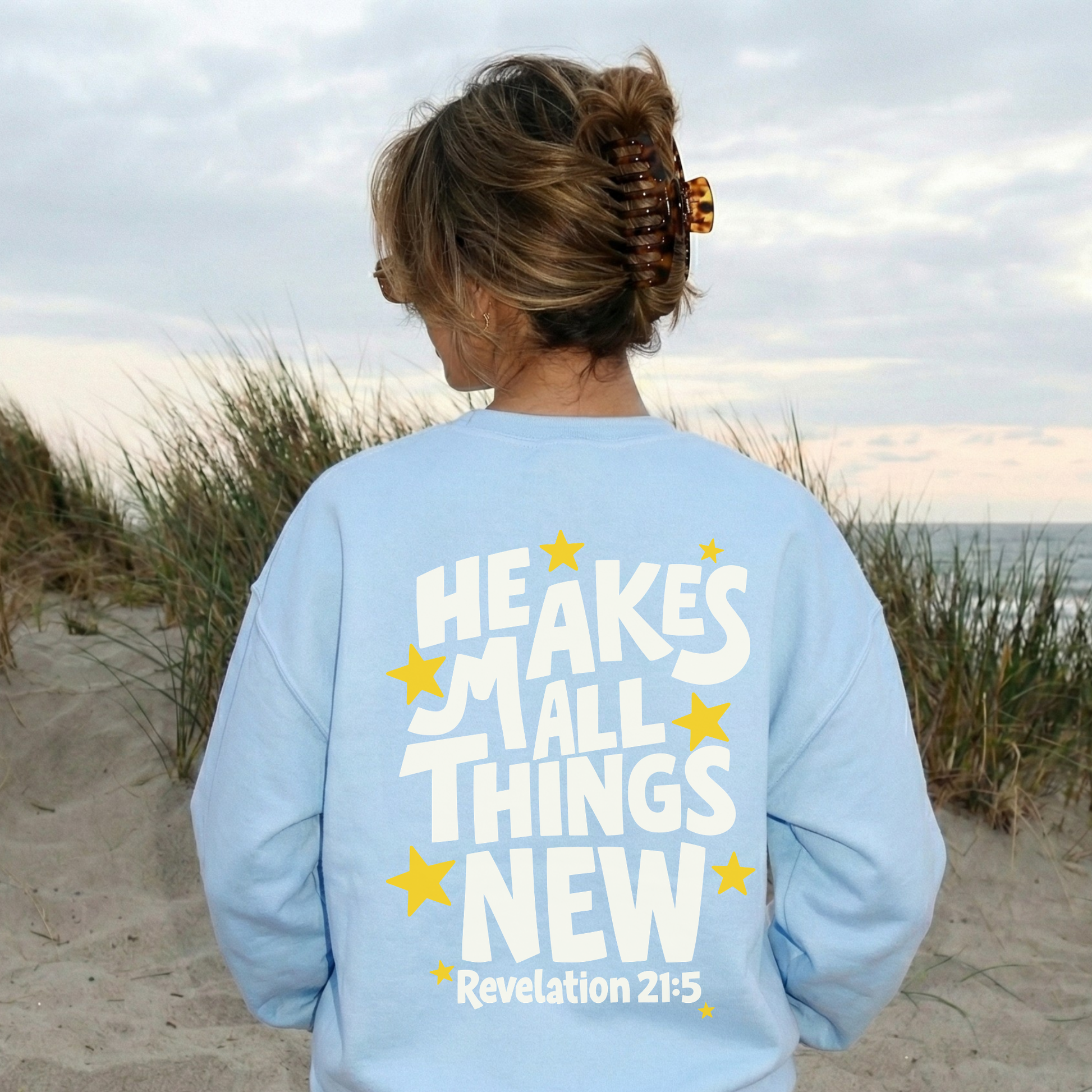light blue christian crewneck sweatshirt he makes all things new revelation 21:5 beach aesthetic faith graphic sweatshirt back view