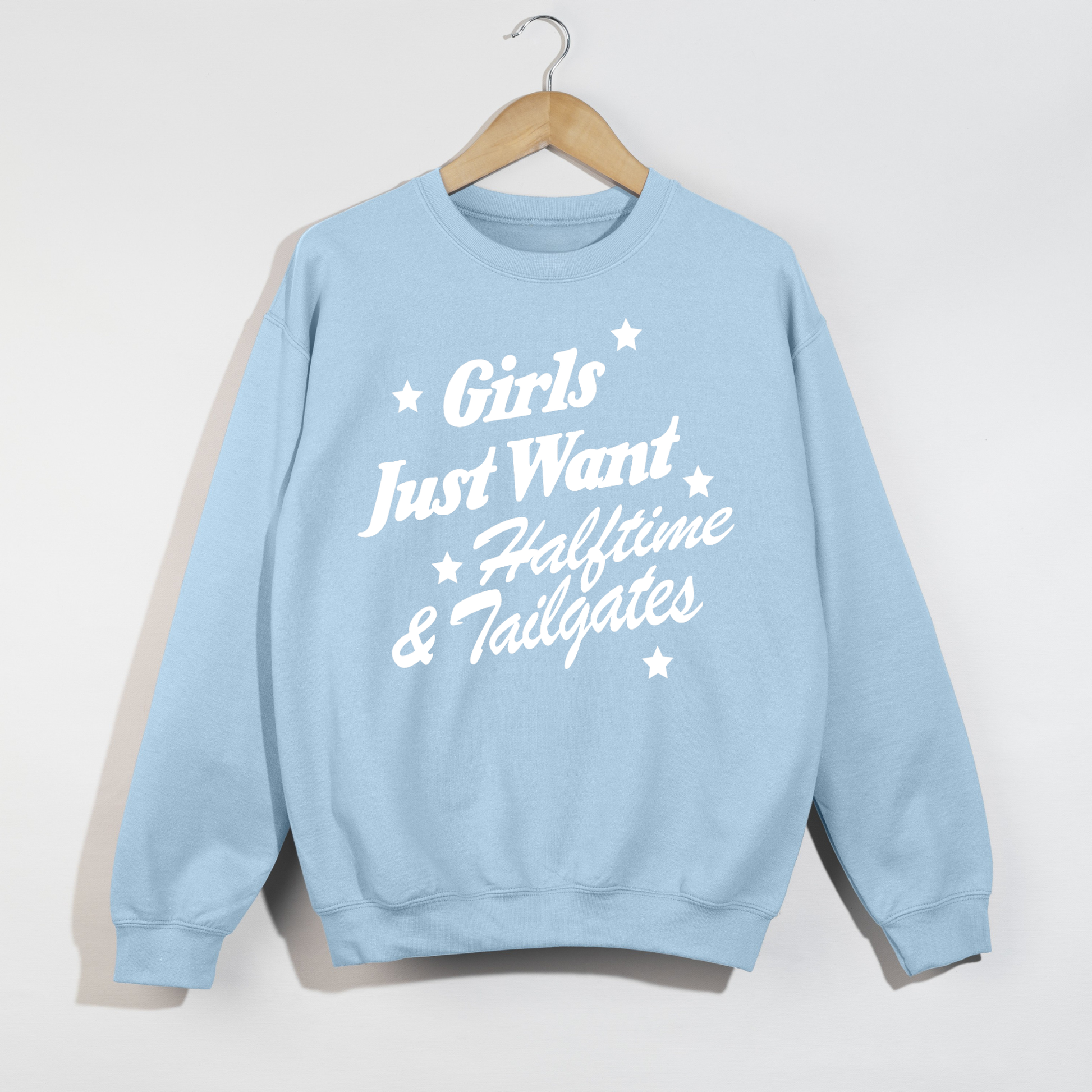 Light blue crewneck sweatshirt featuring the "Girls Just Want Halftime & Tailgates" football season graphic in bold white retro lettering.