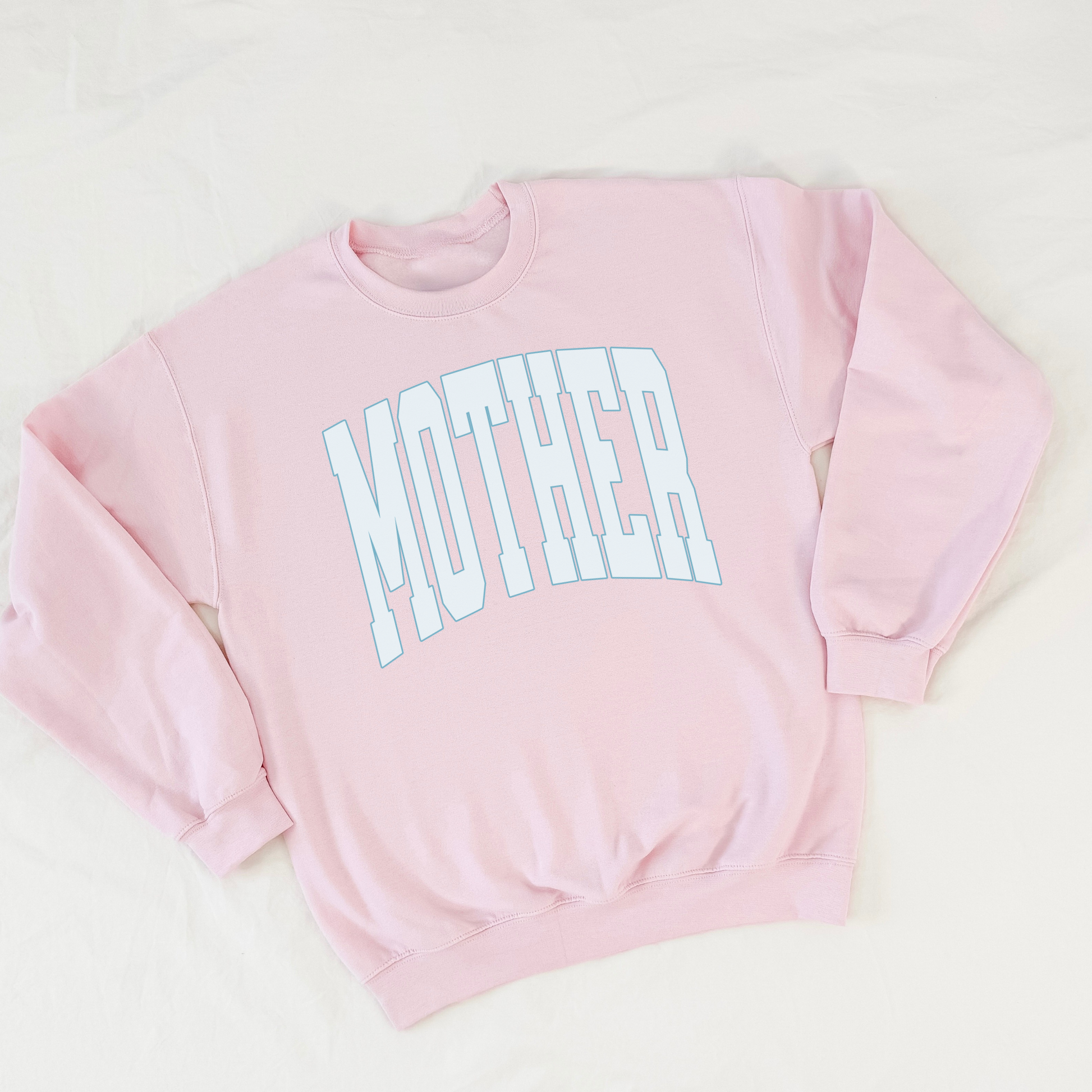 Flat lay of light pink MOTHER crewneck sweatshirt on white background