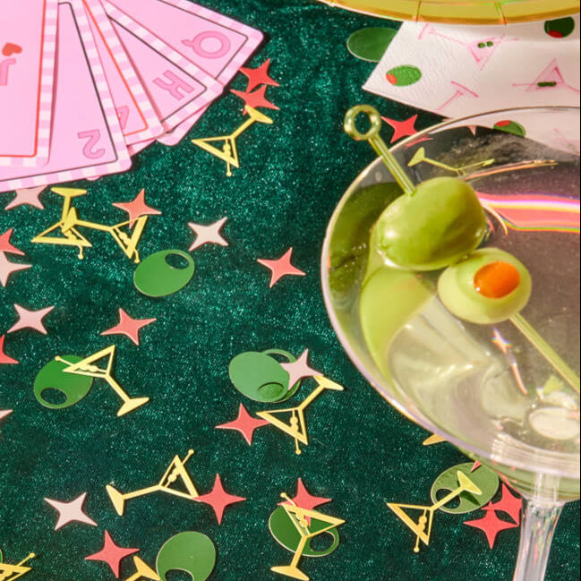 Martini themed foil confetti styled with cocktail glass and party cards for girls night table decor