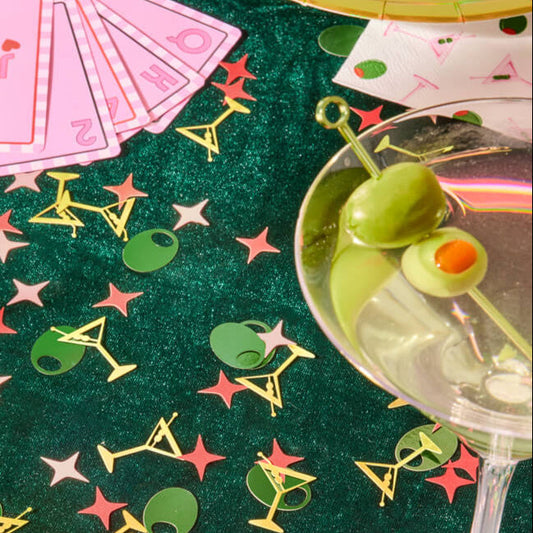 Martini themed foil confetti styled with cocktail glass and party cards for girls night table decor