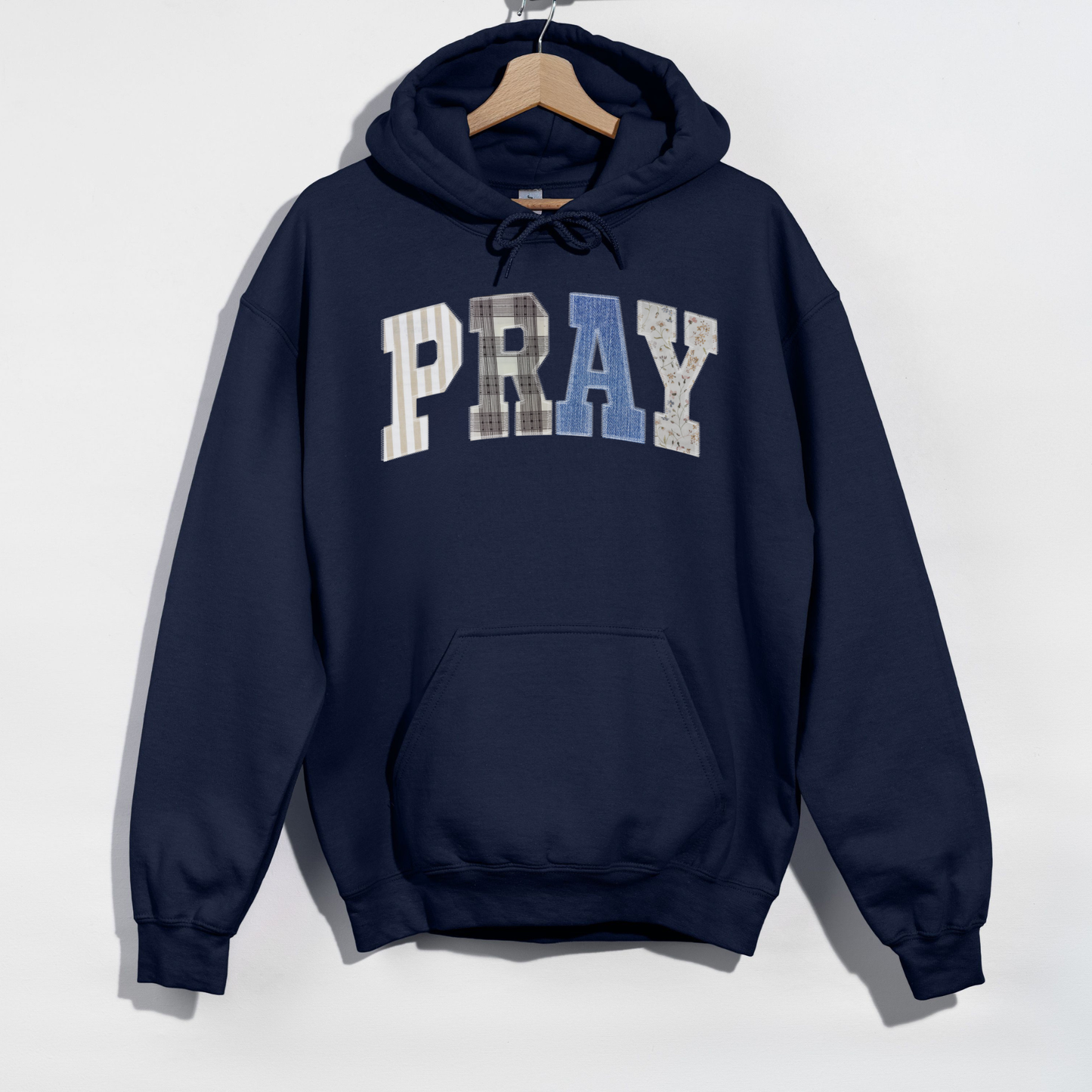 Navy PRAY hoodie flat lay on hanger with kangaroo pocket detail